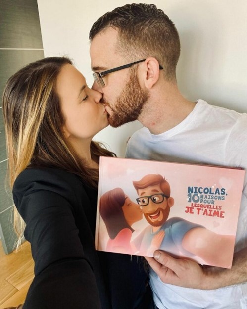 A couple kissing with a personalized book for couples in their hands.