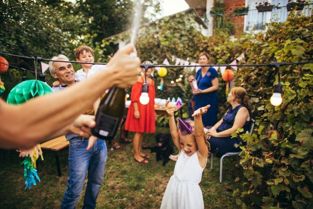 Adults and kids having fun at a kids outdoor birthday party.