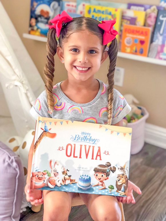 Girl holding a personalized Birthday book by Hooray Heroes.