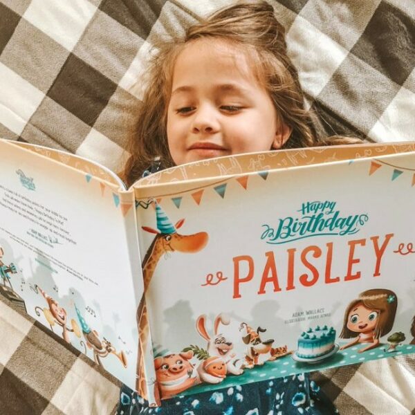 A little girl reading her own personalized book from Hooray Heroes.